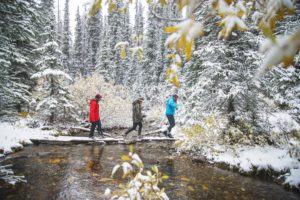 Hikers Crossing A Snowy Stream towards Rummel Lake