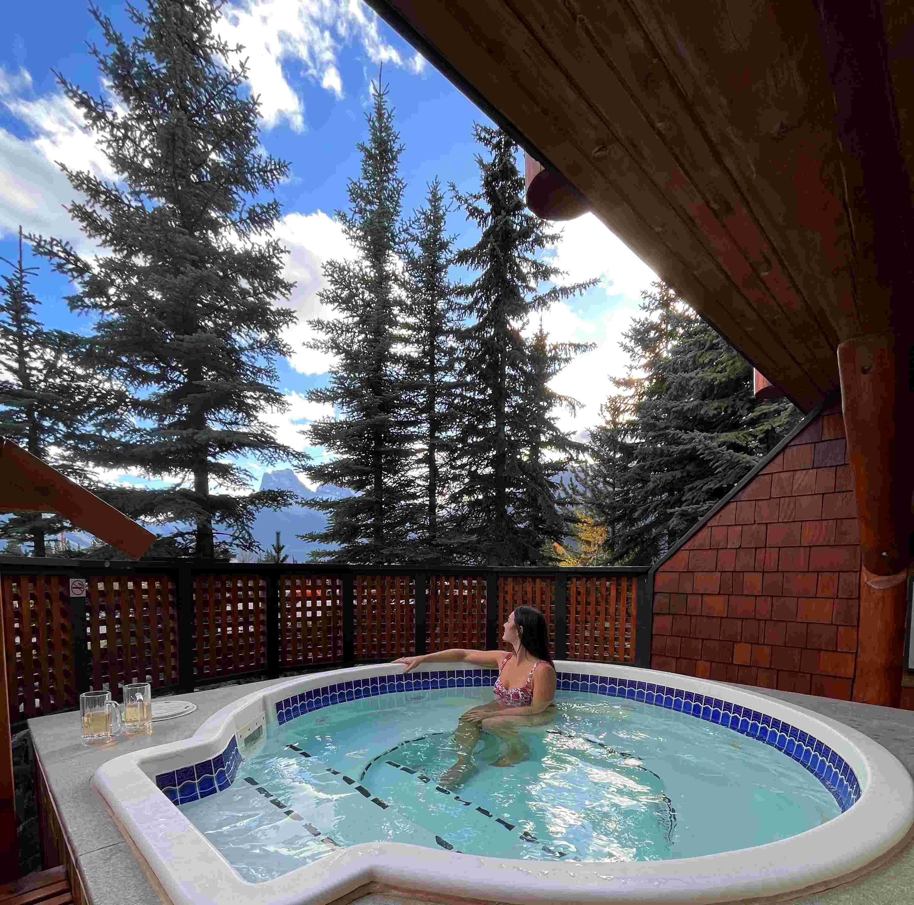 Woman looking at mountain view from hot tub in Canmore Alberta