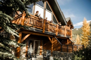 Bride with her wedding party on the balcony of A Bear and Bison Inn during larch season in Canmore.